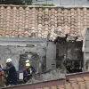 Bomberos y organismos de socorro llegan para atender la emergencia, luego de que una avioneta se estrellara en un barrio residencial hoy en Medellín