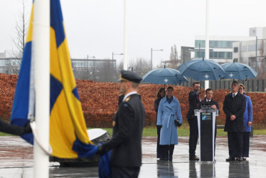 El primer ministro sueco, Ulf Kritersson, pronunciando un discurso durante la ceremonia de alzamiento de la bandera de Suecia en la sede de la OTAN en Bruselas. A su lado están la princesa heredera de Suecia, Victoria, y Jens Stoltenberg, el secretario general de la OTAN. 