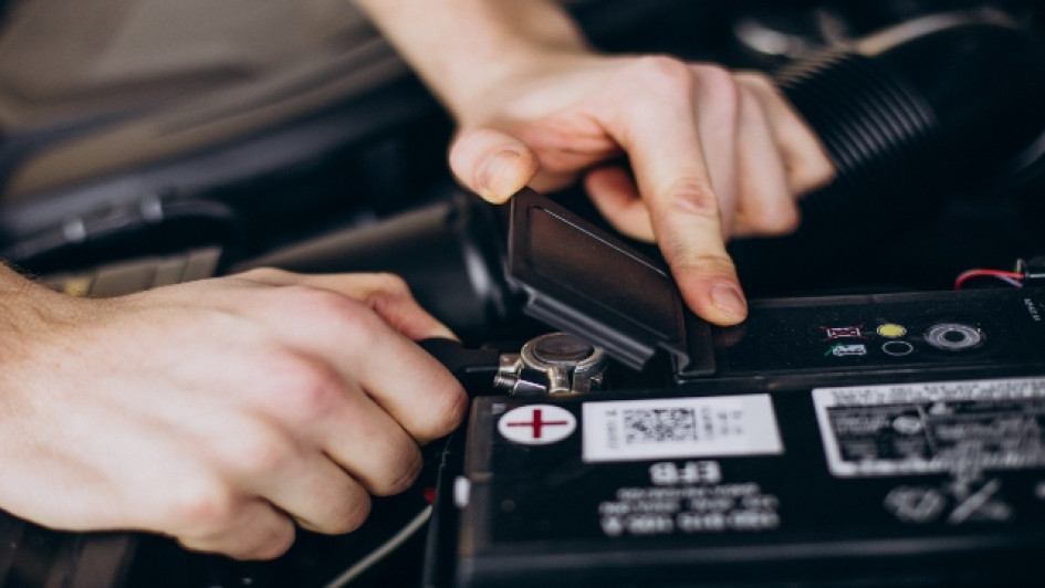 Mejores-baterias-para-carro Hombre revisando la batería de un carro.