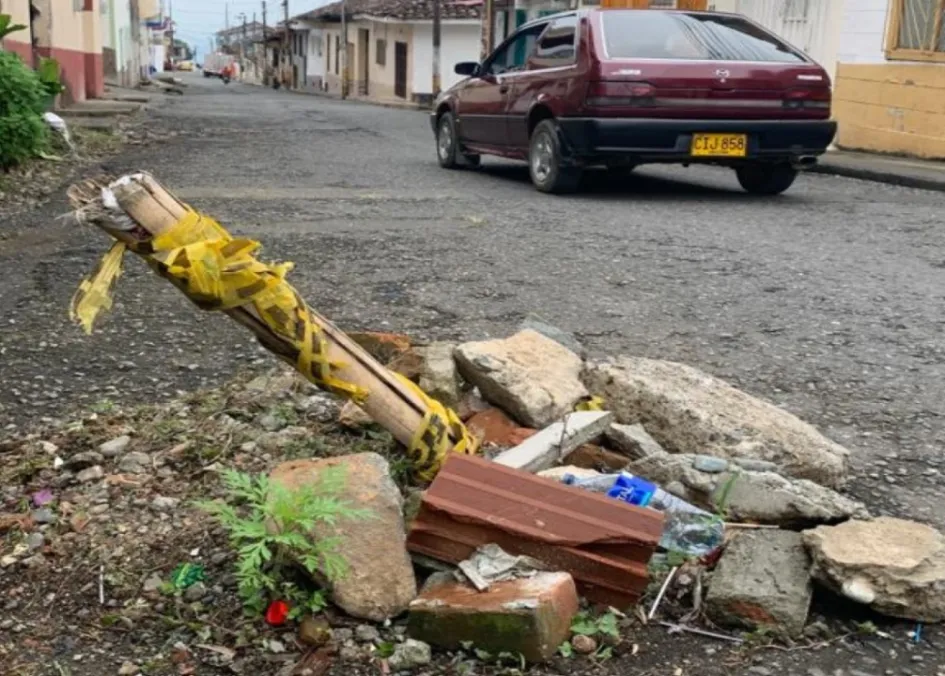 Algunos rotos en la vía están llenos de escombros y guaduas que nadie recoge.