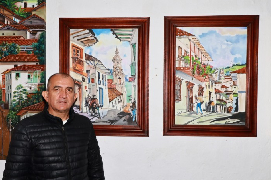 El fotógrafo salamineño Willman Vásquez con las acuarelas de Luis Hernández. El fotógrafo salamineño Willman Vásquez con las acuarelas de Luis Hernández.