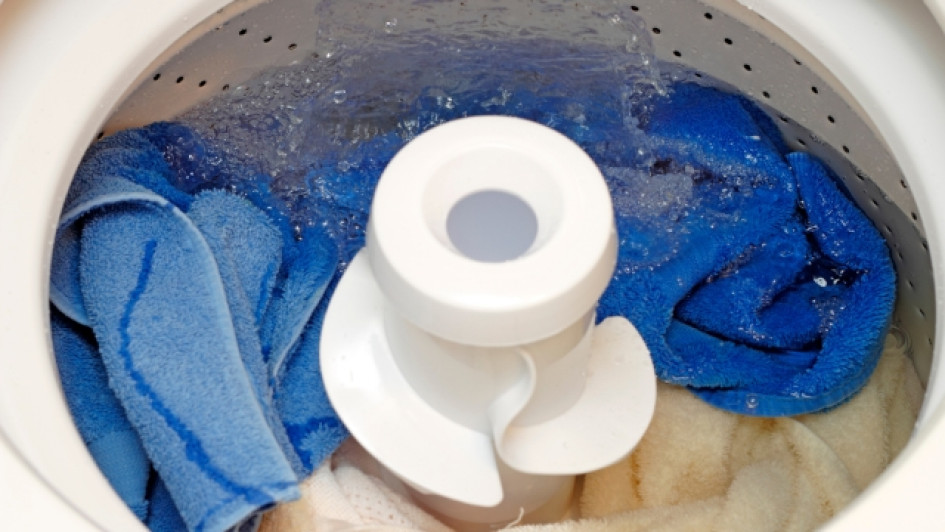 Se-puede-dejar-la-lavadora-con-agua-toda-la-noche Lavadora abierta llena de ropa y agua.