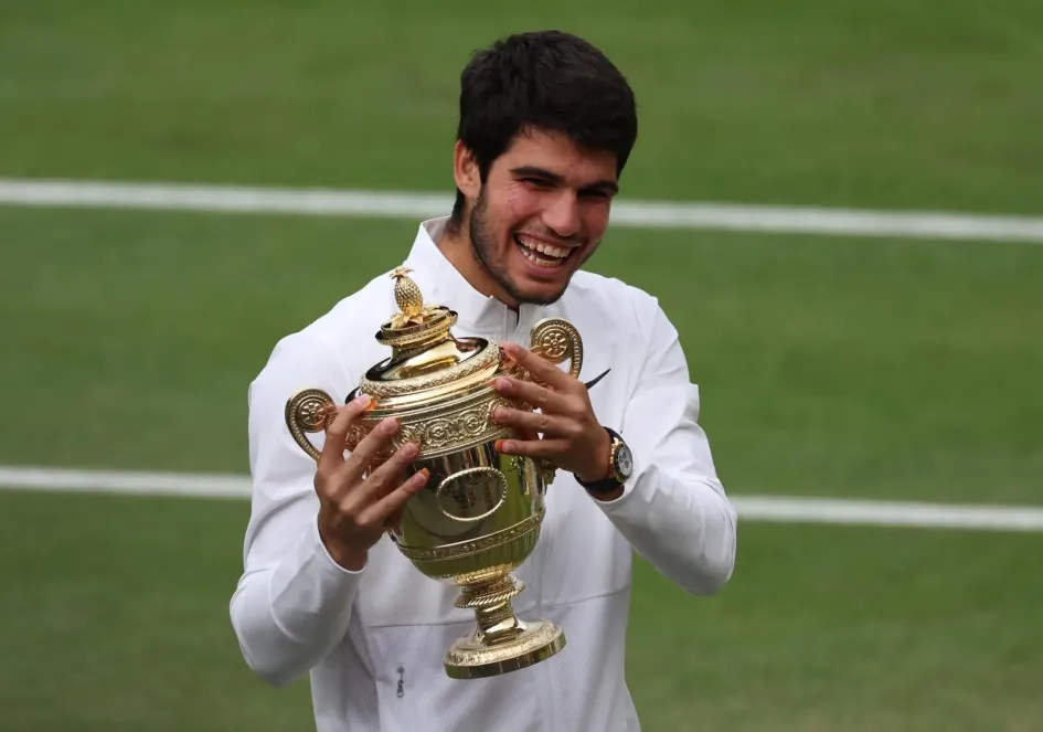 Carlos Alcaraz de España celebra con su trofeo después de ganar su último partido individual masculino contra Novak Djokovic de Serbia en el Campeonato de Wimbledon, en Gran Bretaña. Carlos Alcaraz de España celebra con su trofeo después de ganar su último partido individual masculino contra Novak Djokovic de Serbia en el Campeonato de Wimbledon, en Gran Bretaña.