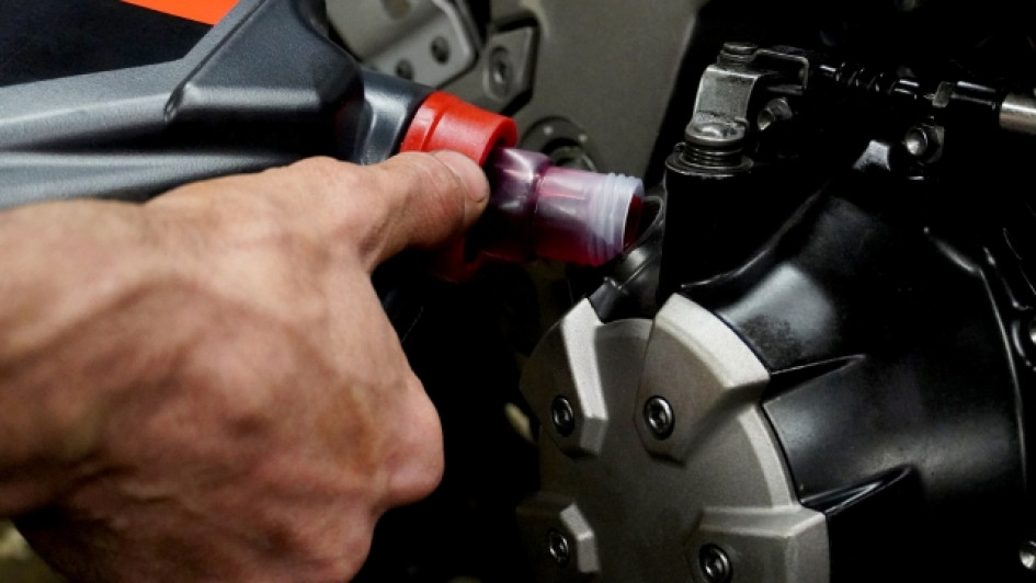 Cada-cuanto-se-cambia-el-aceite-de-una-moto Mano echando aceite al motor de una moto.