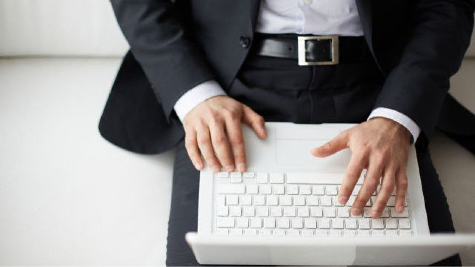 Como-hacer-una-carta-de-remision-de-documentos Hombre elegante con un computador portatil blanco en sus piernas.