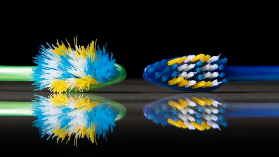 Dos cepillos de dientes al lado, uno gastado y uno nuevo.