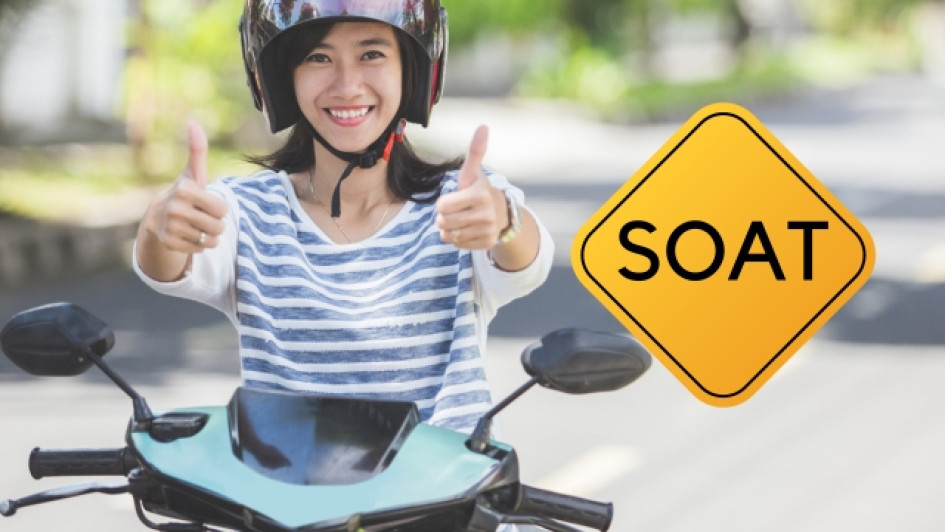 Como-saber-si-mi-moto-tiene-soat Mujer en moto al lado de un aviso que dice "SOAT"
