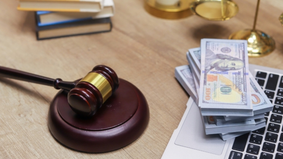 Que-es-cobro-juridico Martillo de juez al lado de un fajo de billetes y libros.