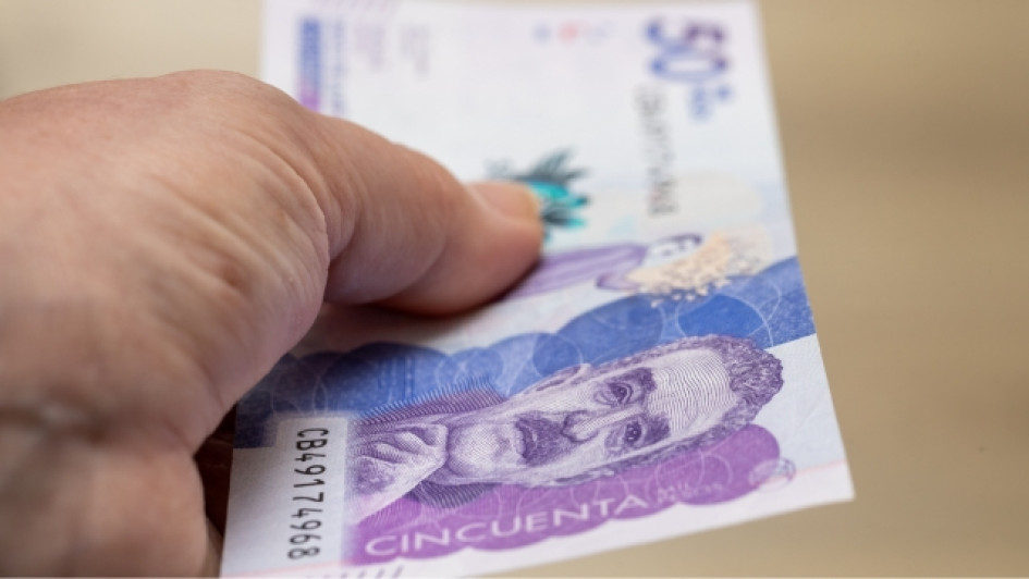 Hasta-cuando-hay-plazo-de-pagar-el-impuesto-vehicular Mano sosteniendo un billete de 50 mil pesos colombianos.