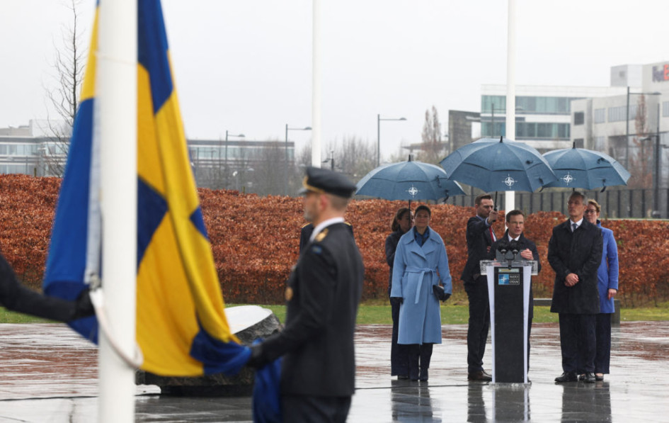 El primer ministro sueco, Ulf Kritersson, pronunciando un discurso durante la ceremonia de alzamiento de la bandera de Suecia en la sede de la OTAN en Bruselas. A su lado están la princesa heredera de Suecia, Victoria, y Jens Stoltenberg, el secretario general de la OTAN. 