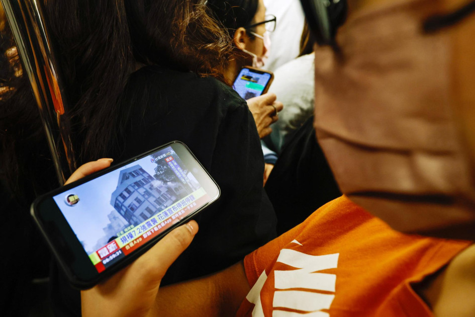 Pasajero de un tren en Taipei observa las noticias sobre el terremoto. Pasajero de un tren en Taipei observa las noticias sobre el terremoto.