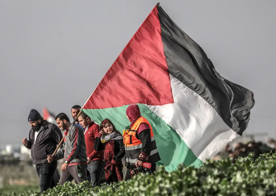Varios palestinos portan una bandera. Varios palestinos portan una bandera.