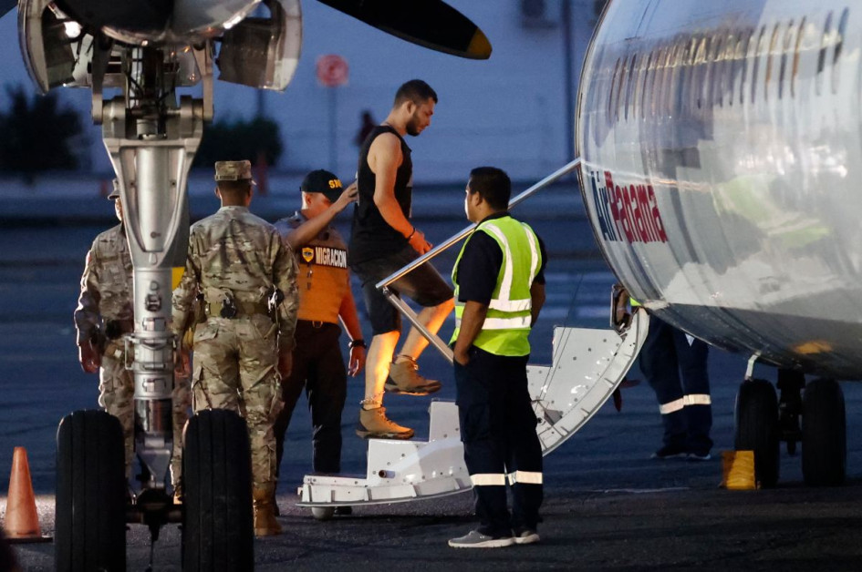 Un migrante sube a un avión para ser deportado a Colombia. Un migrante sube a un avión para ser deportado a Colombia.