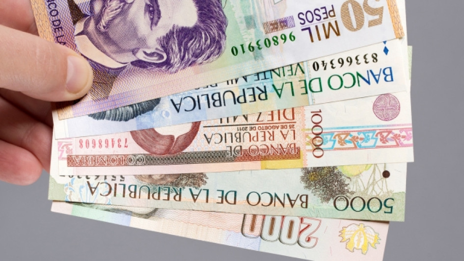 Que-pasa-si-no-pago-impuesto-de-carro-moto Mano sosteniendo pesos colombianos
