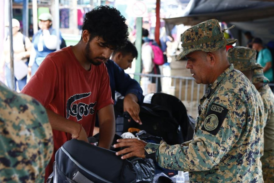 Fotografía del 8 de octubre de 2024 de un migrante siendo requisado por un integrante del Servicio Nacional de Fronteras, en el puesto de Bajo Chiquito (Panamá). Fotografía del 8 de octubre de 2024 de un migrante siendo requisado por un integrante del Servicio Nacional de Fronteras, en el puesto de Bajo Chiquito (Panamá).