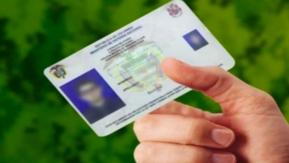 Mano sosteniendo una libreta militar colombiana.