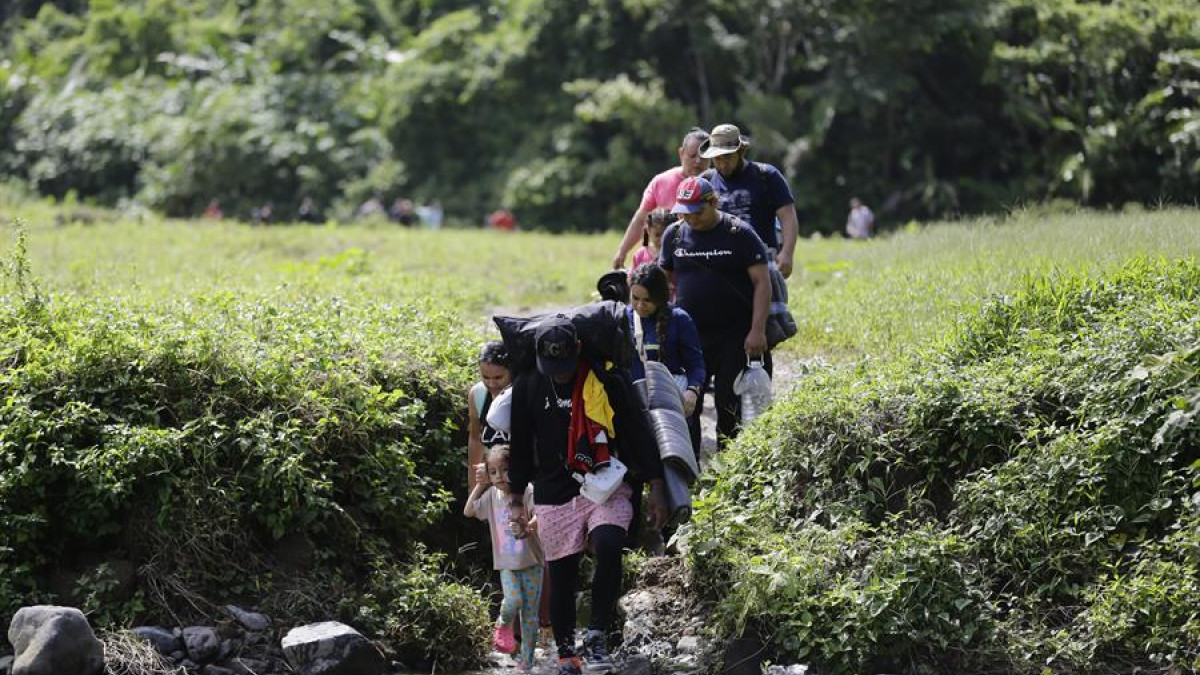 Unos migrantes acompañados con niños pequeños caminan en el sector de Cañas Blancas en Darién (Panamá), en agosto del 2023. 